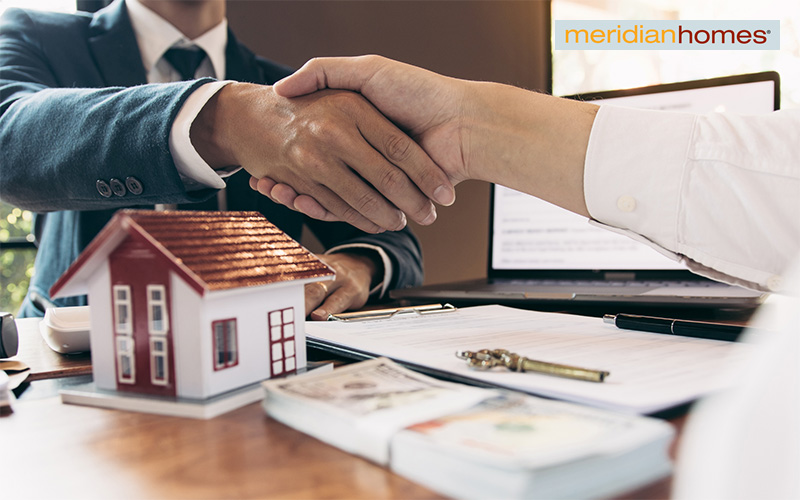 Contractor and client shaking hands after signing agreement.